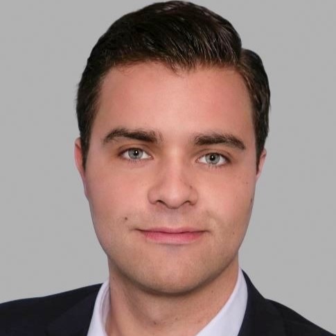 Fabian Pelz_GFA FP Logo mit den Buchstaben GFA in Fettschrift, zentriert in einer grauen ovalen Form, auf einem dunkelblauen Hintergrund mit zwei grauen eckigen Formen oben rechts und unten links.