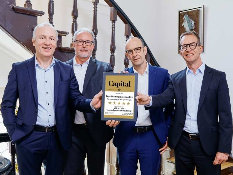 GFA FP_Auszeichnung Das Foto zeigt die vier Geschäftsführer der GFA FP Vermögensverwaltung, die gemeinsam ein Siegel halten, dass sie als Top-Vermögensverwalter für ausgewogene Anlagestrategien auszeichnet.