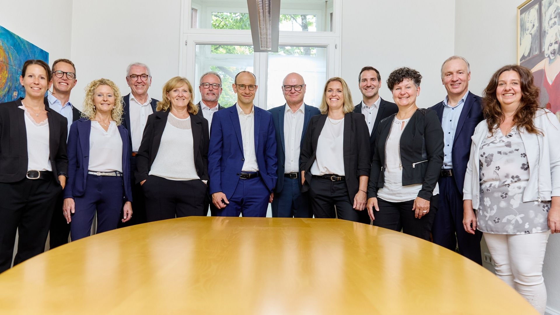 GFA FP_Team Eine Gruppe Menschen steht um einen Tisch herum.